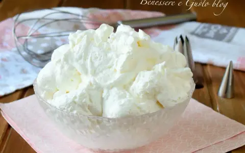 Montare la panna è facile con le fruste giuste. Ecco una ciotola piena di panna montata soffice, pronta per decorare dolci.