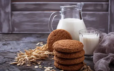 Biscotti farina di avena friabilissimi, perfetti con un bicchiere di latte fresco. Un'immagine che evoca colazioni genuine e momenti di puro piacere.
