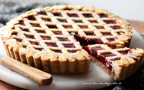 Torta Linzer ricetta originale: crostata con marmellata di lamponi e mandorle a lamelle, un classico della pasticceria.