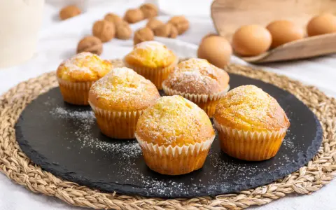 Sei muffin allo yogurt spolverati di zucchero a velo, pronti per essere gustati.