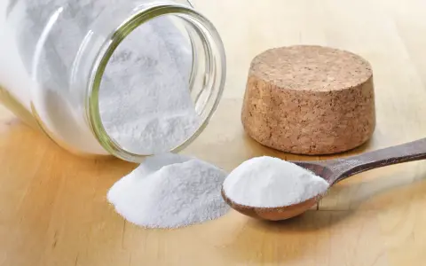 Bicarbonato in un barattolo rovesciato e un cucchiaio: ecco a cosa serve il bicarbonato nei dolci per renderli soffici e lievitati.