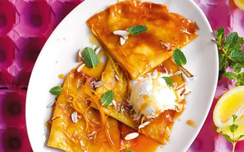 Crepes flambé con gelato, mandorle e scorza d'arancia. Ecco cosa serve per fare le crepes: farina, uova, latte, burro e zucchero.