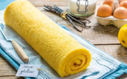 Rotolo giallo soffice, un delizioso pasta biscotto senza glutine, pronto per essere gustato. Ingredienti freschi sullo sfondo.