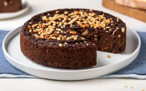 Torta paesana al cioccolato, ricca e umida, guarnita con pinoli tostati. Un dolce rustico che sa di casa.