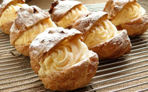 Bignè ripieni di crema pasticcera, spolverati di zucchero a velo. Si può congelare la crema pasticcera per averla sempre pronta.