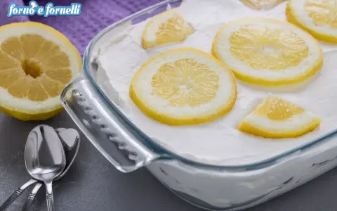 Un delizioso tiramisù al limone, guarnito con fette di limone fresco, pronto per essere gustato.