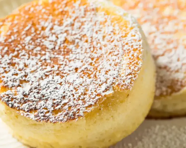 Delicati pancake giapponesi soffici e dorati, spolverati con zucchero a velo.