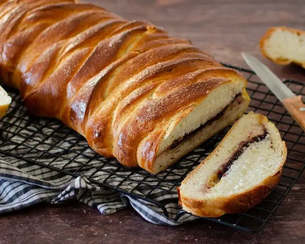 Una deliziosa treccia mochena, dorata e ripiena di marmellata, pronta per essere gustata.
