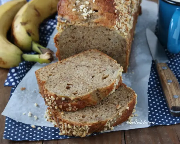 Fetta di banana bread senza burro, soffice e profumato, con croccante copertura di frutta secca. Perfetto per la colazione.