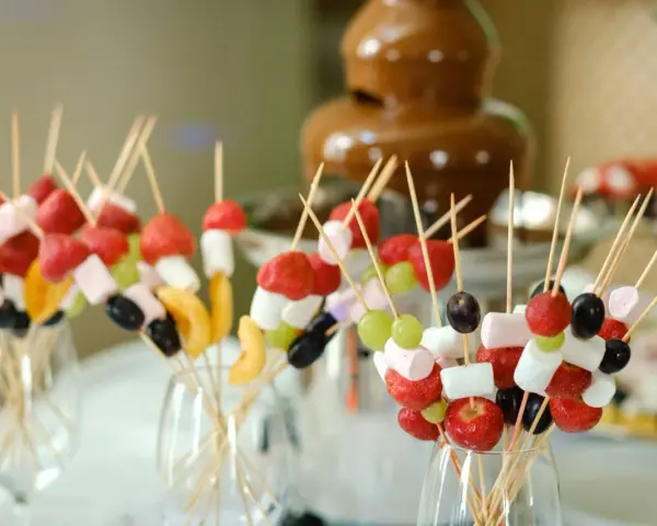 Spiedini di frutta e marshmallow pronti per essere intinti nella fontana di cioccolato come funziona.