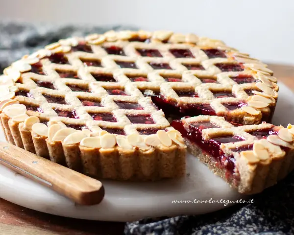 Torta Linzer ricetta originale: crostata con marmellata di lamponi e mandorle a lamelle, un classico della pasticceria.