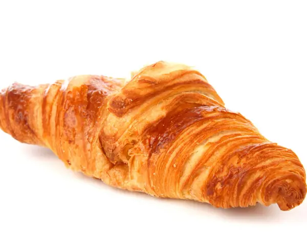 Un delizioso croissant francese, dorato e sfogliato, pronto per una colazione da sogno.