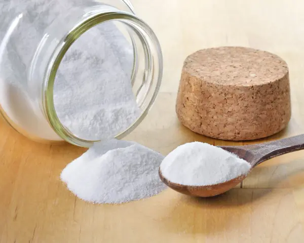 Bicarbonato in un barattolo rovesciato e un cucchiaio: ecco a cosa serve il bicarbonato nei dolci per renderli soffici e lievitati.