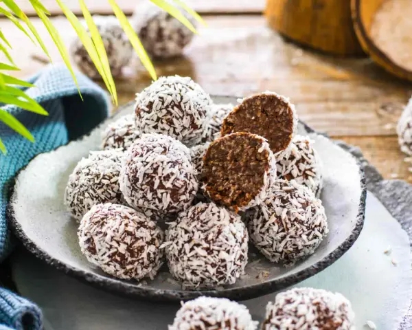 Praline al cioccolato facili e veloci, ricoperte di cocco grattugiato. Un morso rivela un interno morbido e goloso.