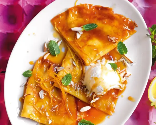Crepes flambé con gelato, mandorle e scorza d'arancia. Ecco cosa serve per fare le crepes: farina, uova, latte, burro e zucchero.