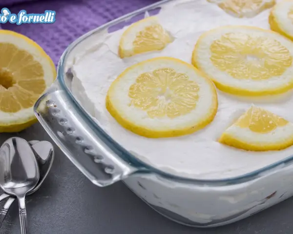 Un delizioso tiramisù al limone, guarnito con fette di limone fresco, pronto per essere gustato.
