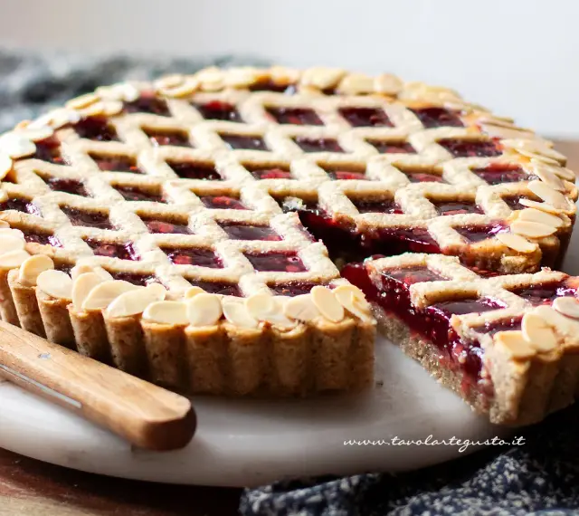 Torta Linzer ricetta originale: crostata con marmellata di lamponi e mandorle a lamelle, un classico della pasticceria.