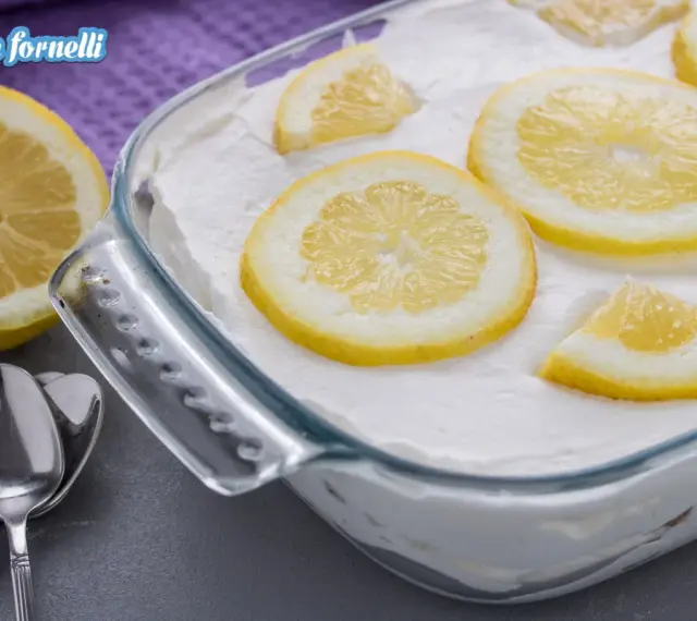 Un delizioso tiramisù al limone, guarnito con fette di limone fresco, pronto per essere gustato.