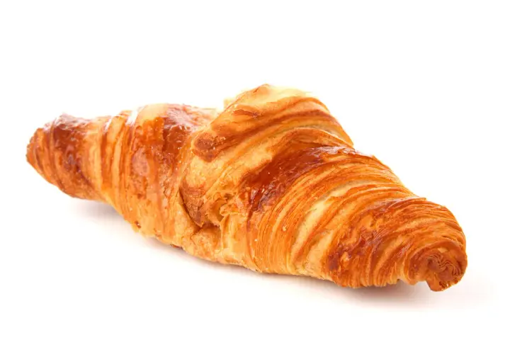 Un delizioso croissant francese, dorato e sfogliato, pronto per una colazione da sogno.