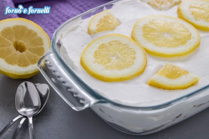 Un delizioso tiramisù al limone, guarnito con fette di limone fresco, pronto per essere gustato.