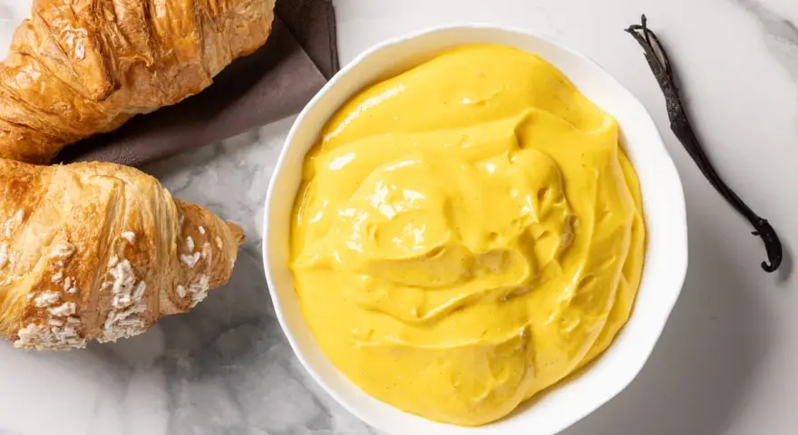 Crema pasticcera senza glutine, vellutata e profumata alla vaniglia, pronta per farcire dolci o da gustare con croissant.