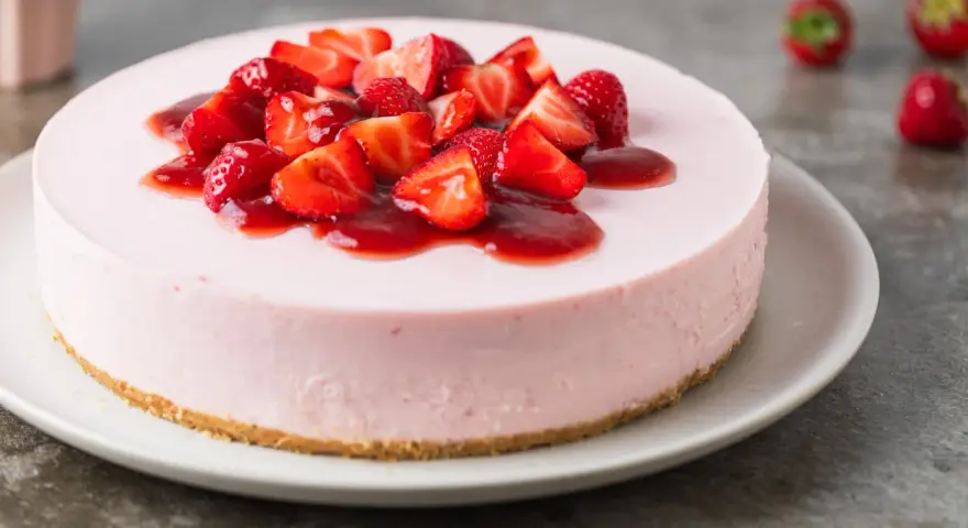 Deliziosa torta fragole e mascarpone senza cottura, guarnita con fragole fresche e salsa rossa.