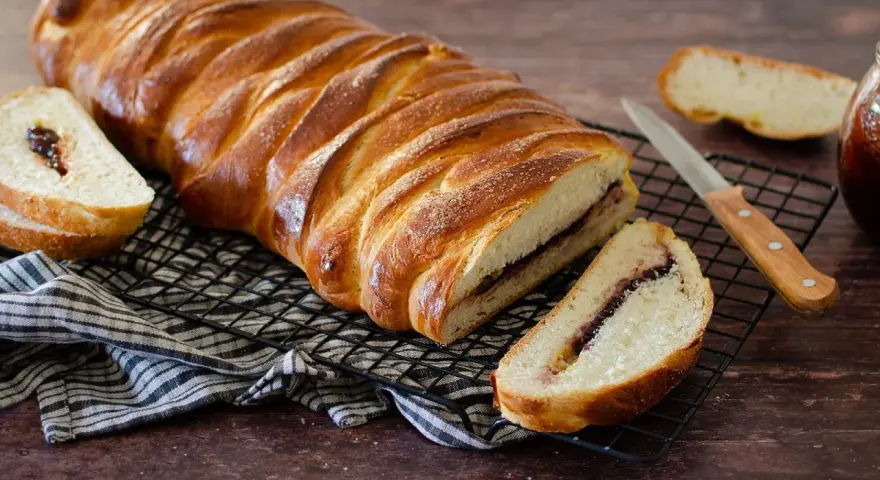 Una deliziosa treccia mochena, dorata e ripiena di marmellata, pronta per essere gustata.