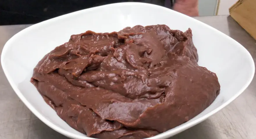 Crema pasticcera al cioccolato, densa e lucida, in una ciotola bianca.