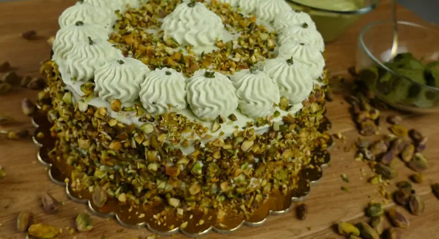 Delizioso dolce con crema al pistacchio già pronta, ricoperto di granella di pistacchi e decorato con ciuffi di crema.