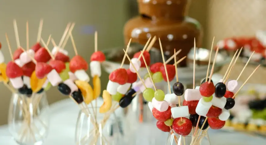 Spiedini di frutta e marshmallow pronti per essere intinti nella fontana di cioccolato come funziona.