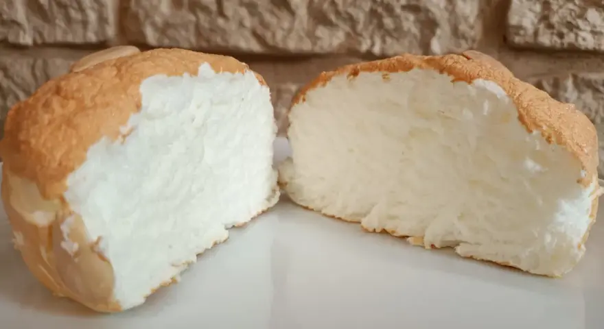 Una fetta di torta nuvola, soffice e leggera, con una crosticina dorata e un interno bianco e arioso.