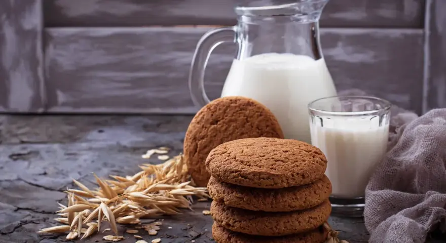 Biscotti farina di avena friabilissimi, perfetti con un bicchiere di latte fresco. Un'immagine che evoca colazioni genuine e momenti di puro piacere.