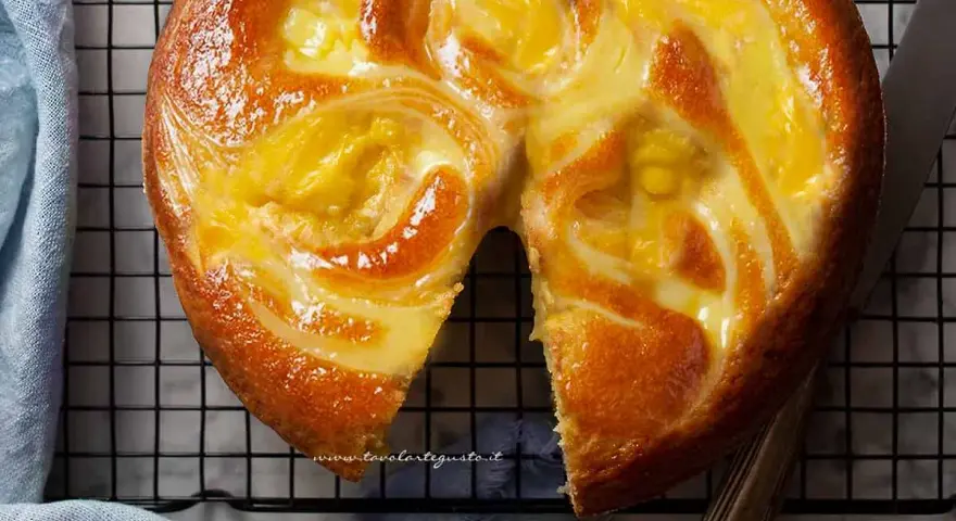 Torta soffice con un vortice di crema pasticcera dorata, appena sfornata e pronta per essere gustata.