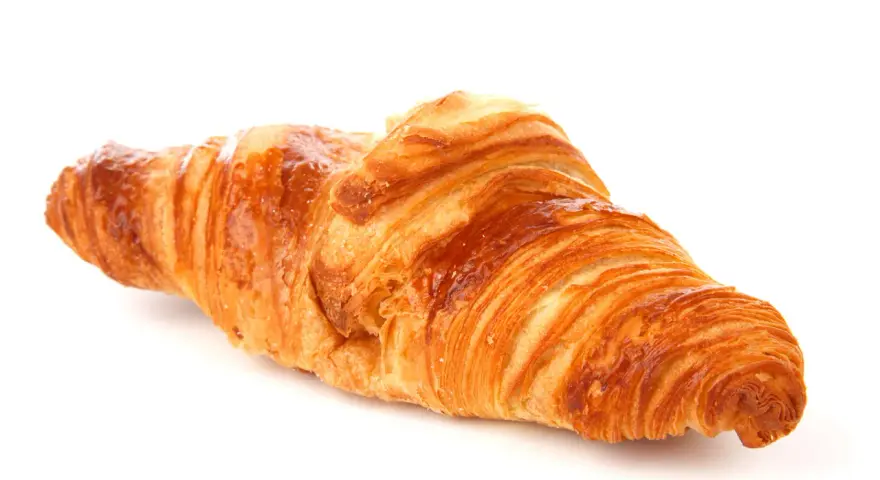 Un delizioso croissant francese, dorato e sfogliato, pronto per una colazione da sogno.