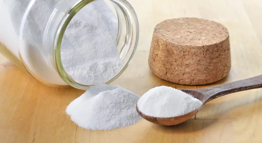 Bicarbonato in un barattolo rovesciato e un cucchiaio: ecco a cosa serve il bicarbonato nei dolci per renderli soffici e lievitati.