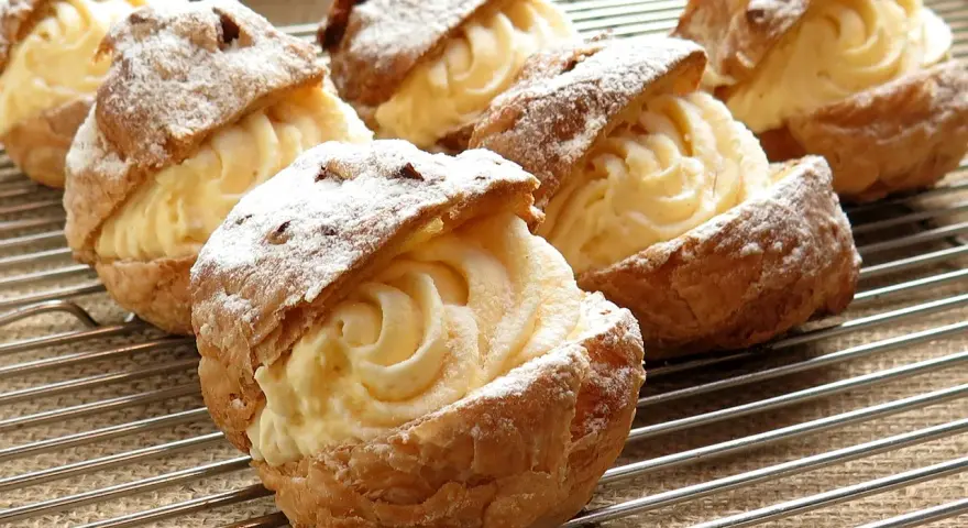 Bignè ripieni di crema pasticcera, spolverati di zucchero a velo. Si può congelare la crema pasticcera per averla sempre pronta.