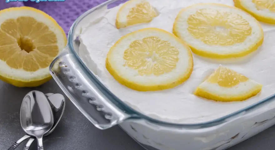 Un delizioso tiramisù al limone, guarnito con fette di limone fresco, pronto per essere gustato.