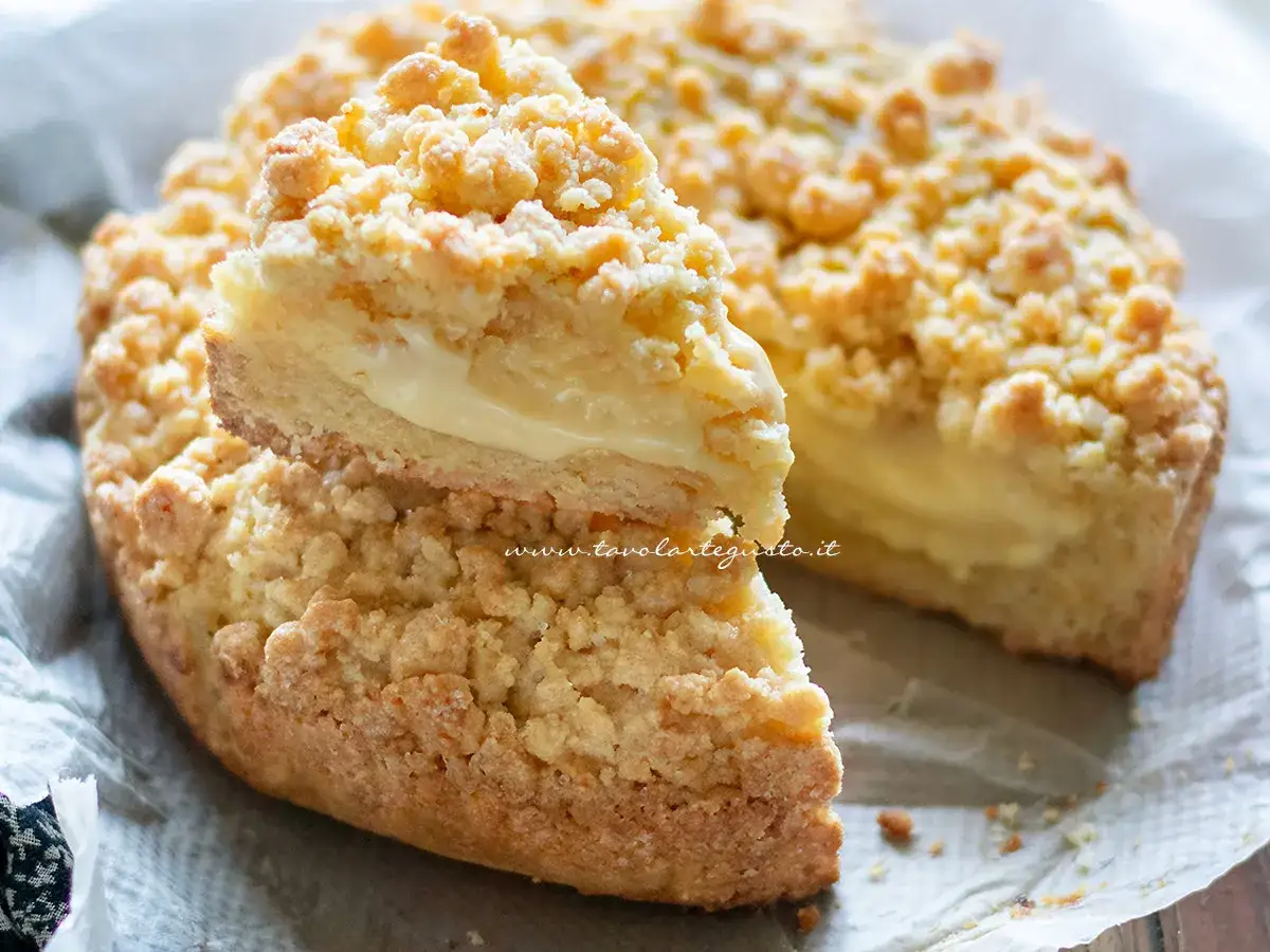 Una fetta di sbrisolona con crema pasticcera, con la sua croccante copertura e il ripieno morbido e goloso.
