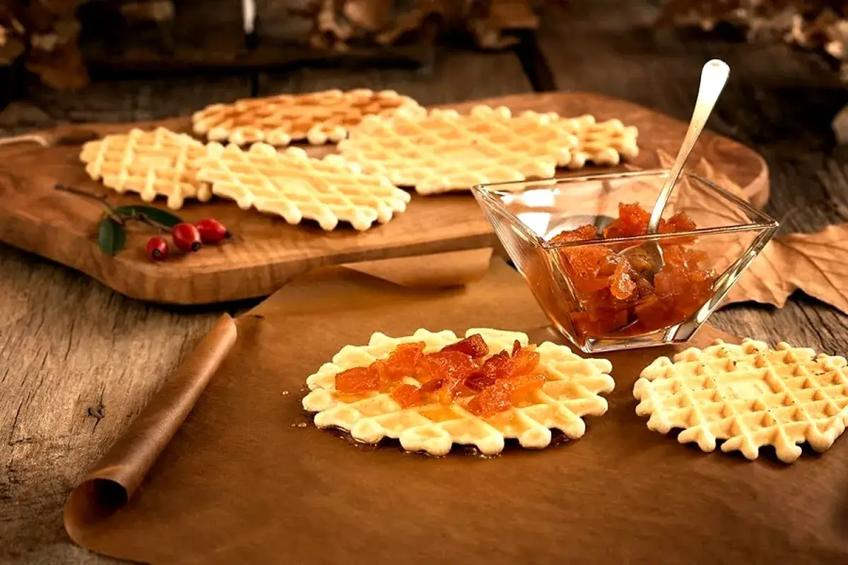 Ferratelle abruzzesi, dolci croccanti e dorati, guarnite con marmellata di arance, pronte per essere gustate.