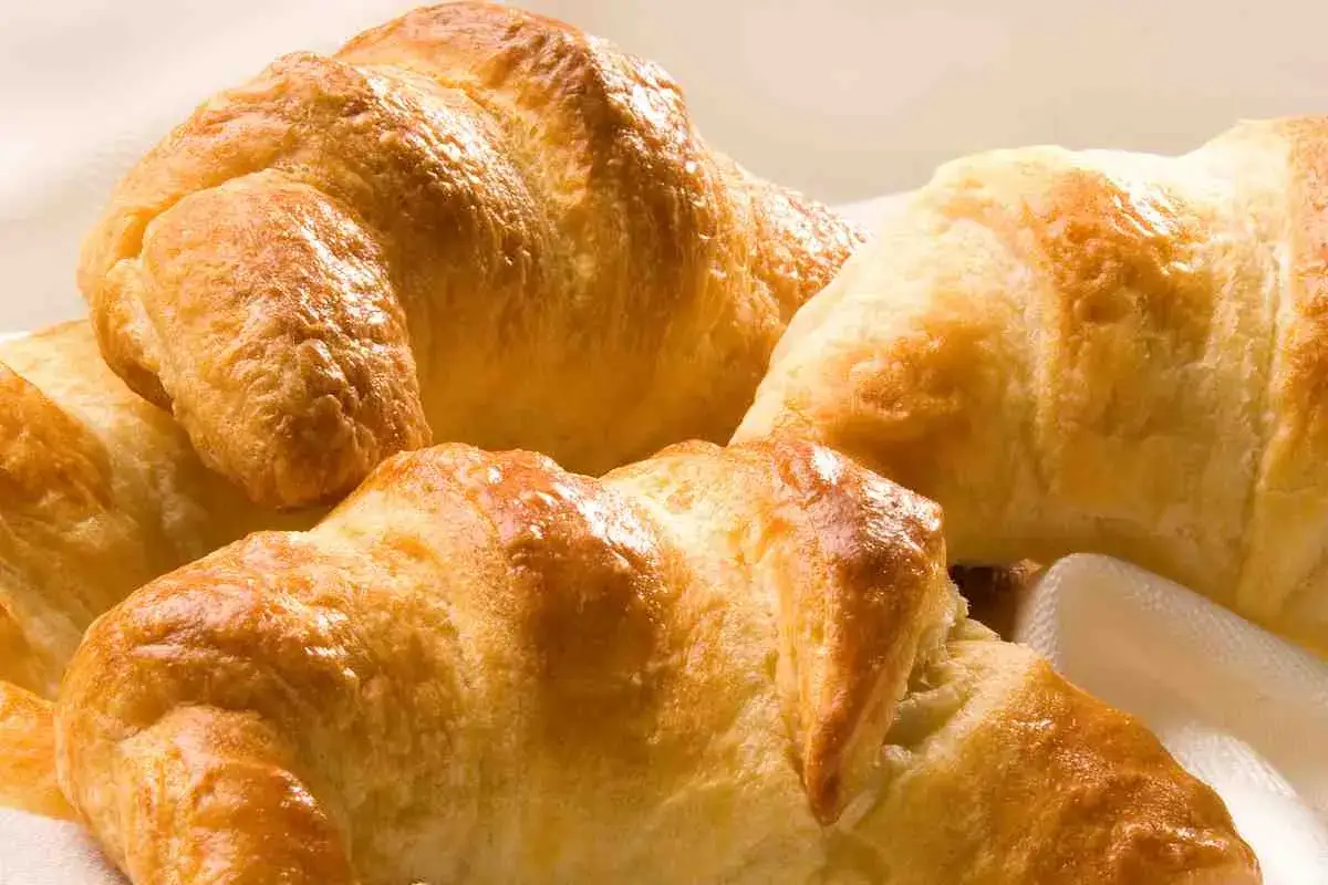 Brioches fatte in casa, dorate e fragranti, pronte per una colazione perfetta.