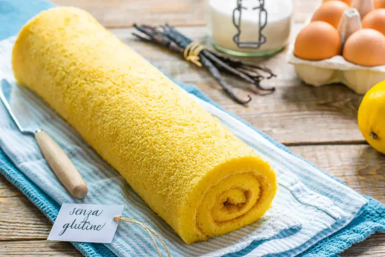 Rotolo giallo soffice, un delizioso pasta biscotto senza glutine, pronto per essere gustato. Ingredienti freschi sullo sfondo.