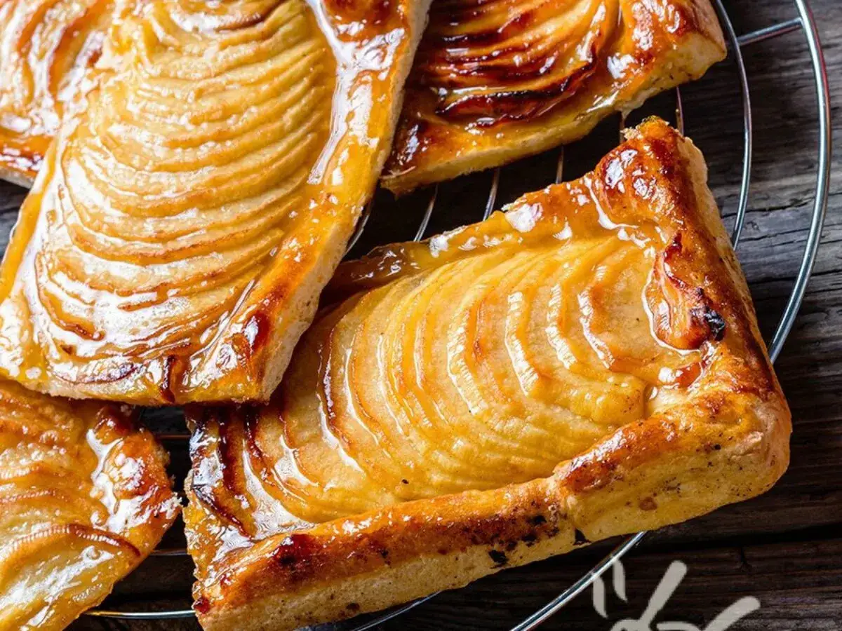 Sfogliatine di pasta sfoglia con zucchero e mele caramellate, dorate e lucide, pronte per essere gustate.
