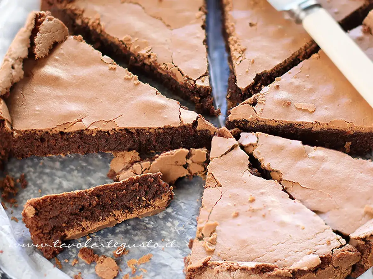 Una torta tenerina cuore morbido, tagliata a fette triangolari, mostra la sua crosta croccante e l'interno umido e goloso.