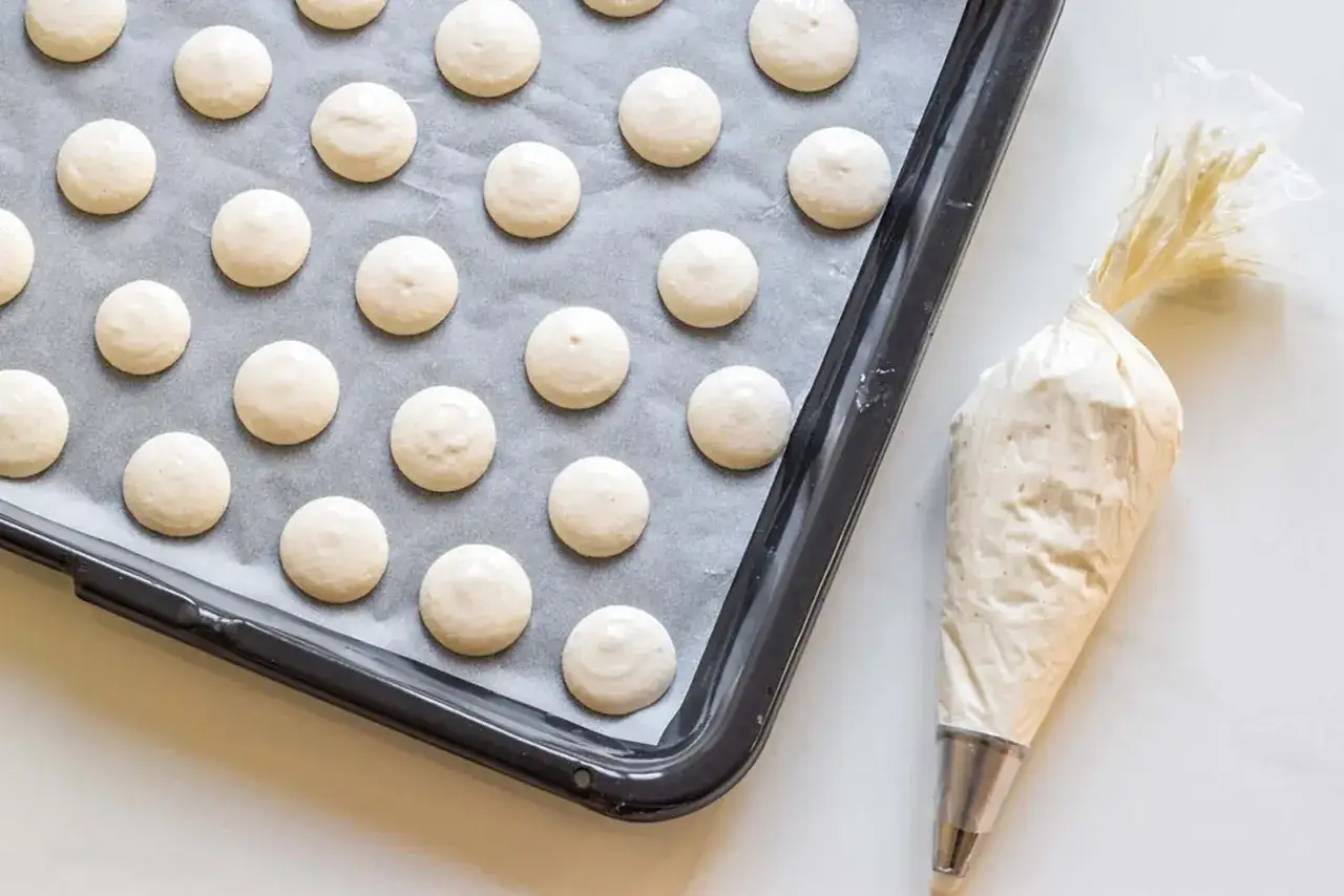 Teglia con gusci di macarons pronti per essere farciti con ganache.