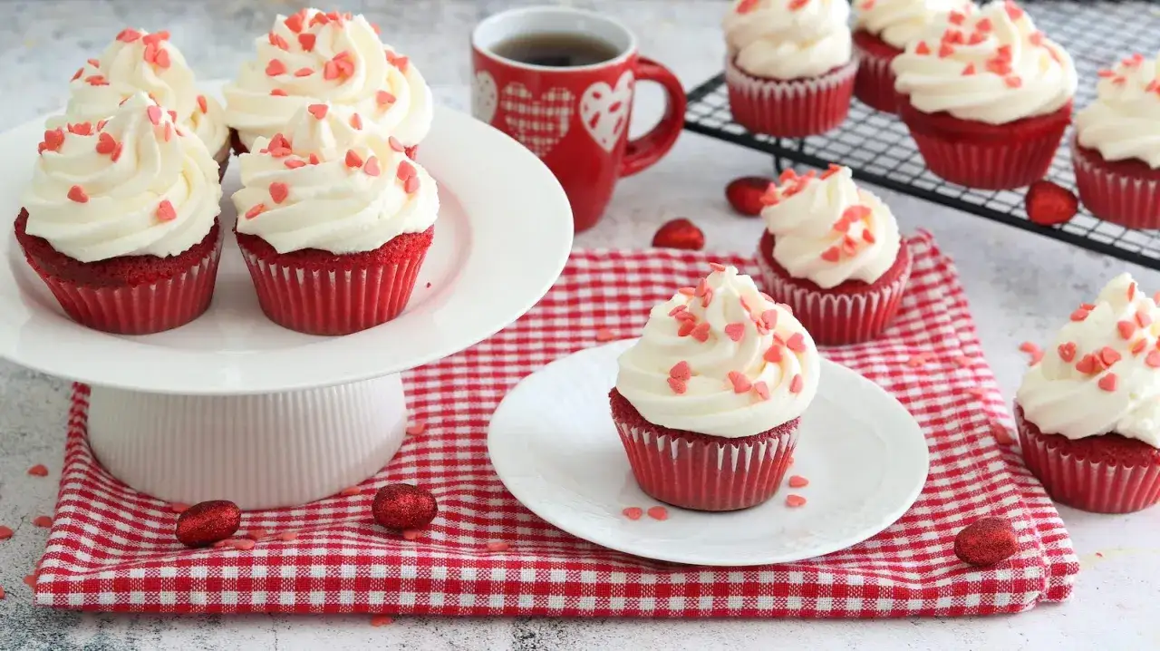 Deliziosi muffin red velvet con glassa bianca e cuoricini rossi, pronti per essere gustati.
