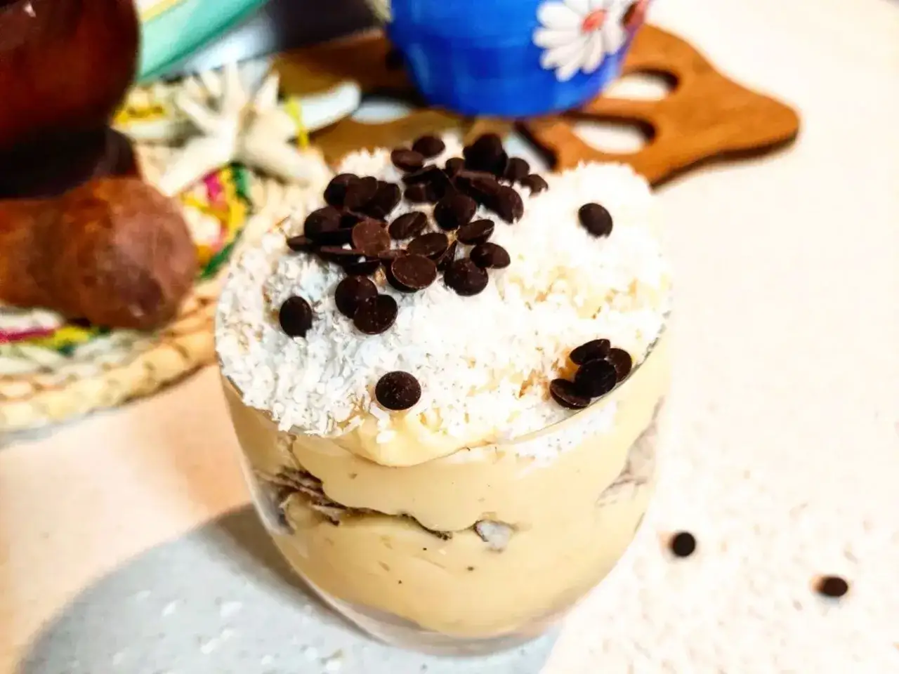 Delizioso dessert a strati con crema al cocco, scaglie di cioccolato e cocco grattugiato.