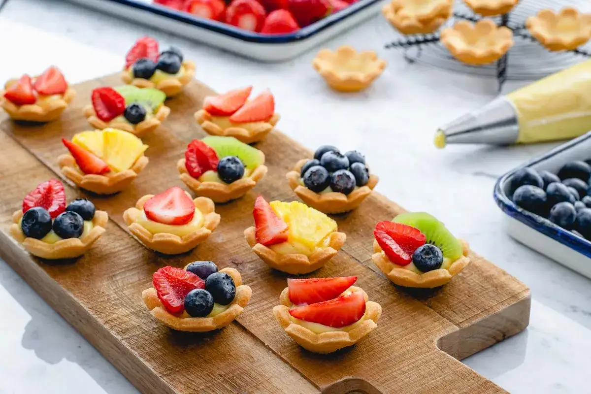 Deliziosi cestini alla frutta con fragole, mirtilli, kiwi e ananas, pronti per essere gustati.