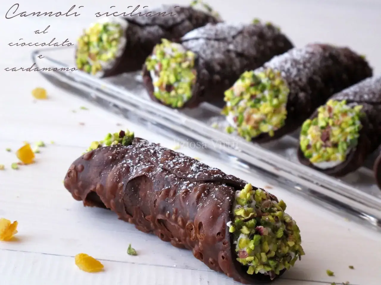 Cannoli siciliani al cioccolato e cardamomo: un ripieno semplice e delizioso. Pistacchi croccanti e zucchero a velo completano questa ricetta.
