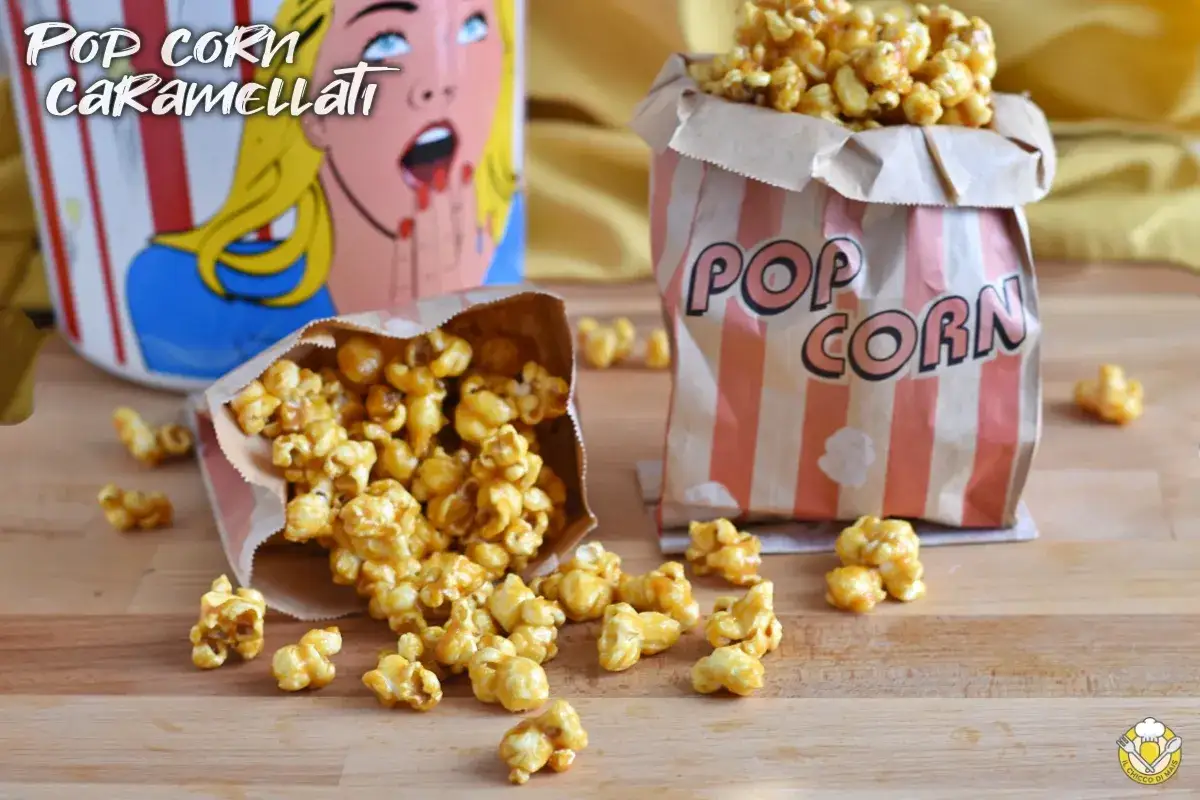 Sacchetti di carta pieni di pop corn caramellati, alcuni sparsi sul tavolo di legno.