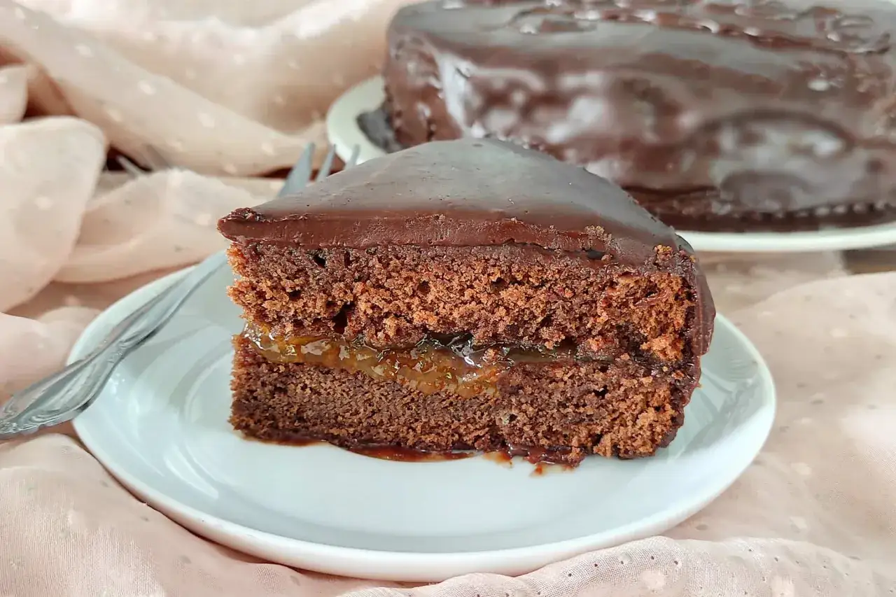 Una fetta di torta Sacher, con la sua glassa al cioccolato lucida e il ripieno di marmellata, evoca le sue origini viennesi.